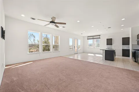 an empty room with windows and ceiling fan