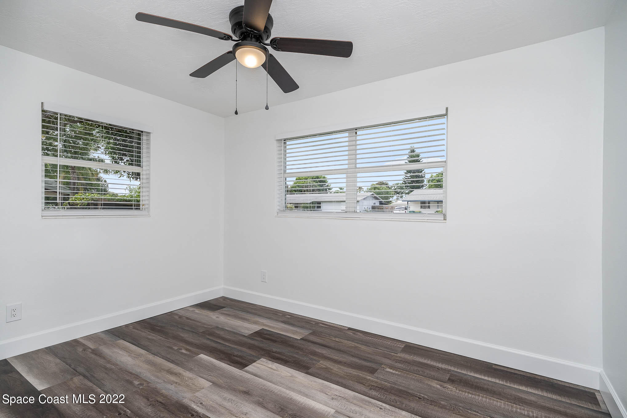 1026 Macco Road Cocoa, FL 32927 - Photo 13 of 20 a view of an empty room with wooden floor and a window