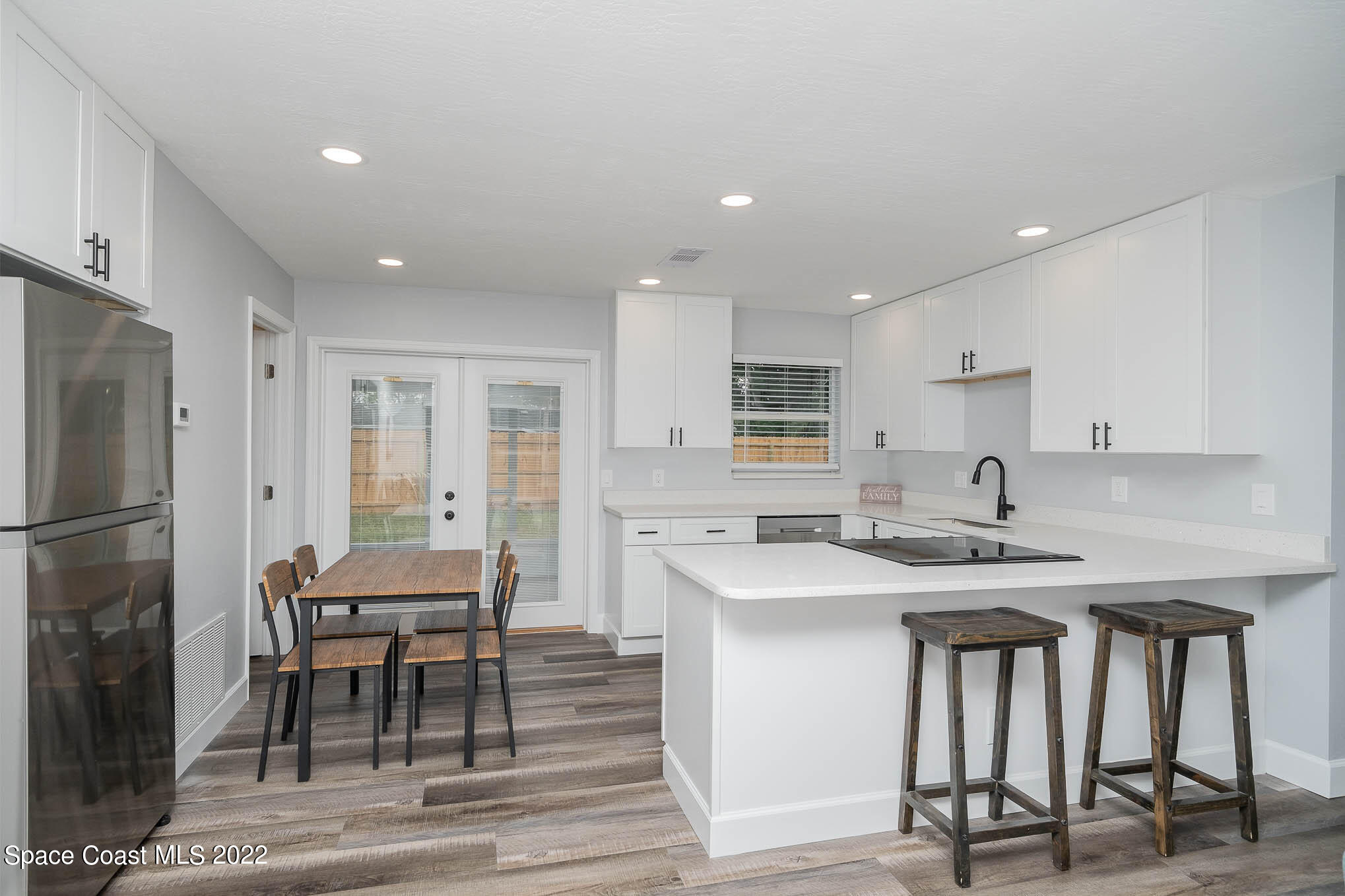 1026 Macco Road Cocoa, FL 32927 - Photo 5 of 20 a kitchen with stainless steel appliances granite countertop a table chairs sink refrigerator and cabinets