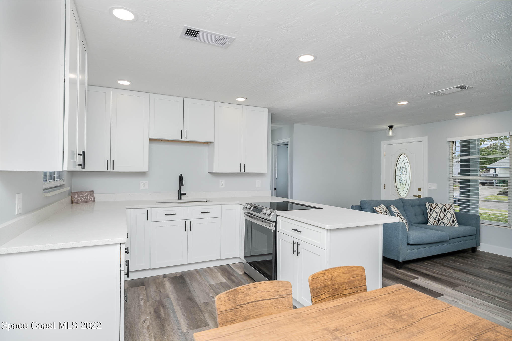 1026 Macco Road Cocoa, FL 32927 - Photo 6 of 20 a kitchen with a stove a sink a refrigerator and white cabinets