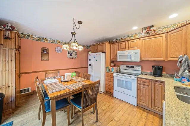 a kitchen that has a table chairs stainless steel appliances and cabinets