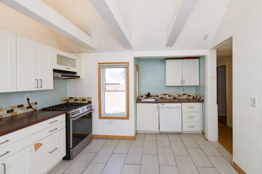 7 Cross Street Natick, MA 01760 - Photo 4 of 31 a kitchen with granite countertop a stove top oven sink and cabinets