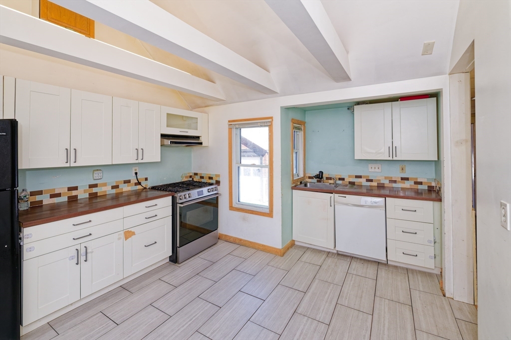 7 Cross Street Natick, MA 01760 - Photo 5 of 31 a kitchen with granite countertop white cabinets and white appliances