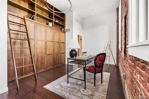 a view of a workspace with furniture and a window