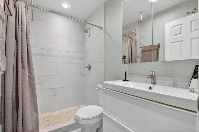 a bathroom with a sink a toilet and shower