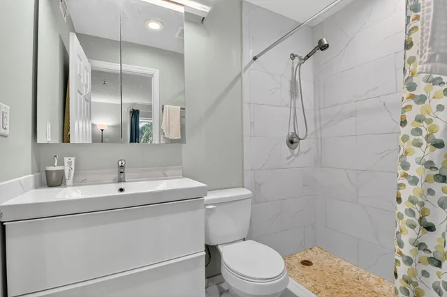 a bathroom with a sink a toilet and shower