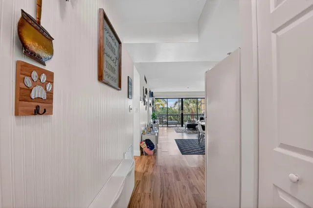 a hallway with a large window and wooden floor