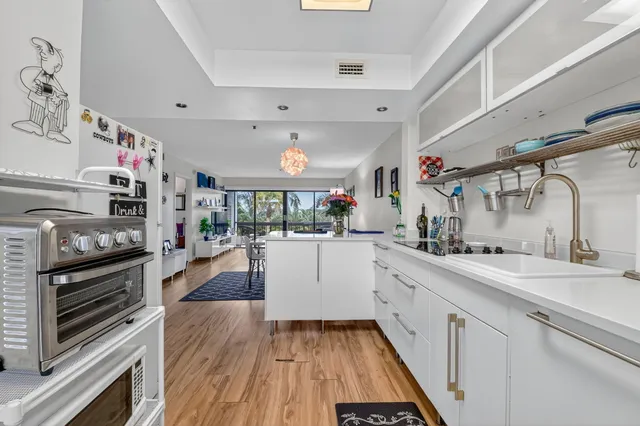 a large white kitchen with lots of counter space and stainless steel appliances