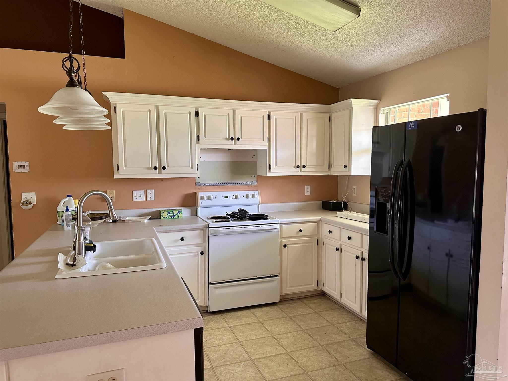 5582 Berrybrook Circle Pace, FL 32571 - Photo 3 of 15 a kitchen with a sink a refrigerator and cabinets