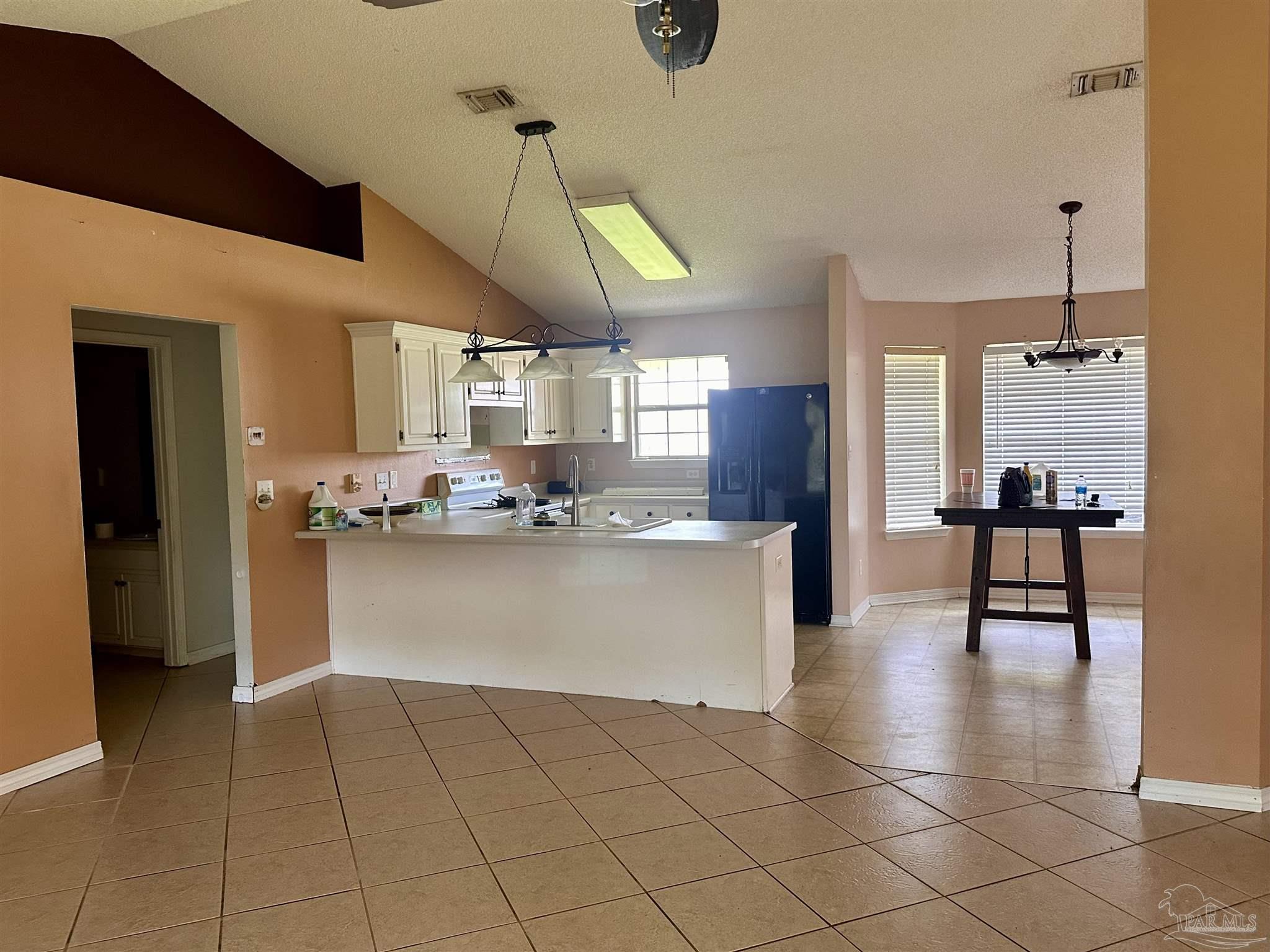 5582 Berrybrook Circle Pace, FL 32571 - Photo 7 of 15 a view of open kitchen with white cabinets and stainless steel appliances
