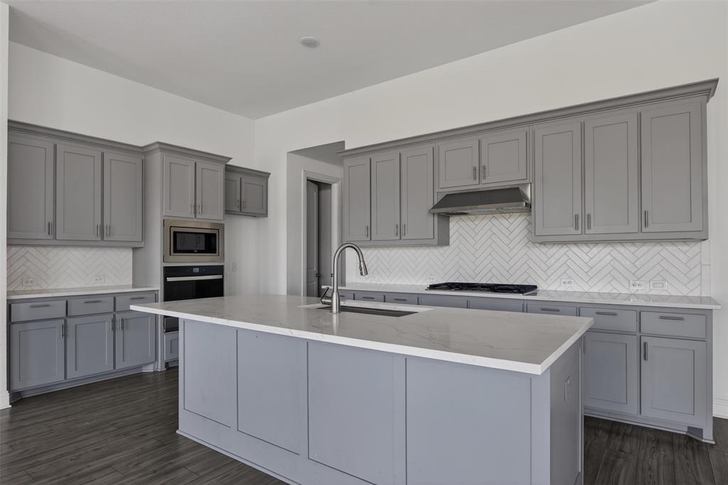 845 Ranchland Road Justin, TX 76247 - Photo 12 of 22 a kitchen with cabinets stainless steel appliances and a sink