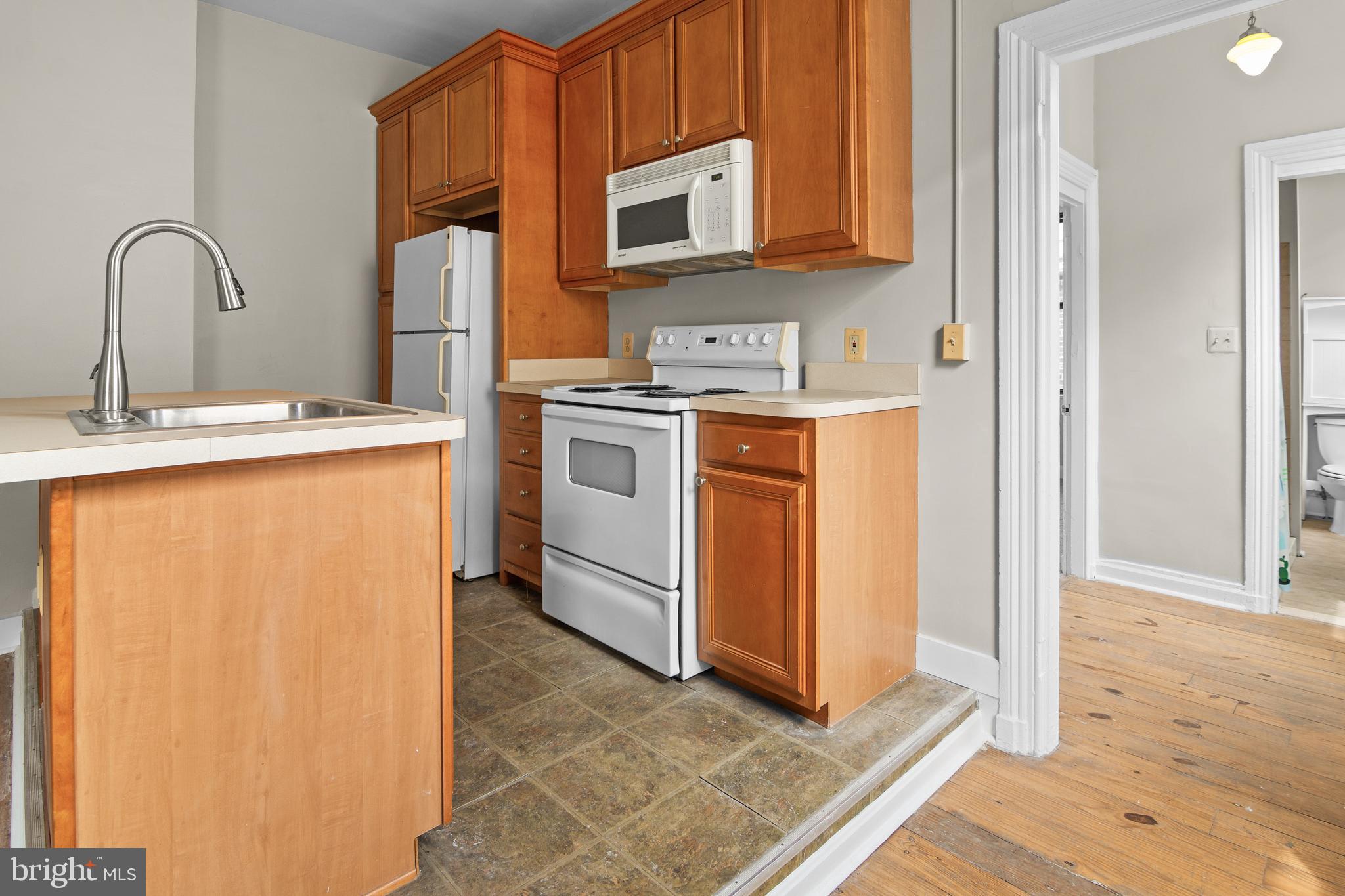 2112 Fleet Street Baltimore, MD 21231 - Photo 19 of 62 a kitchen with stainless steel appliances granite countertop a stove a sink and a microwave