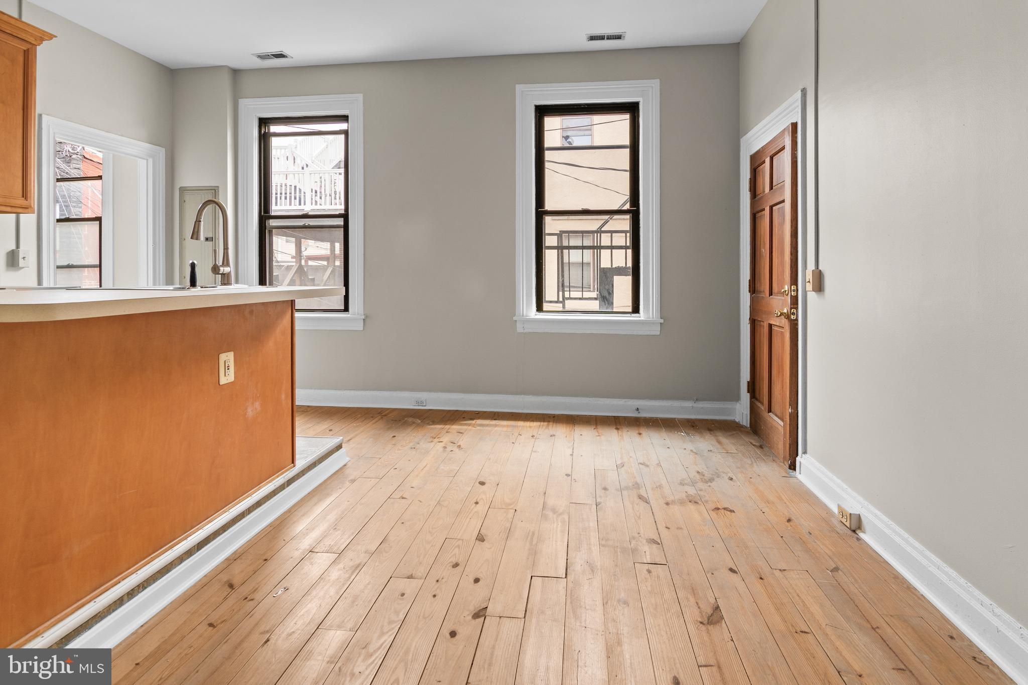 2112 Fleet Street Baltimore, MD 21231 - Photo 22 of 62 an empty room with wooden floor and windows