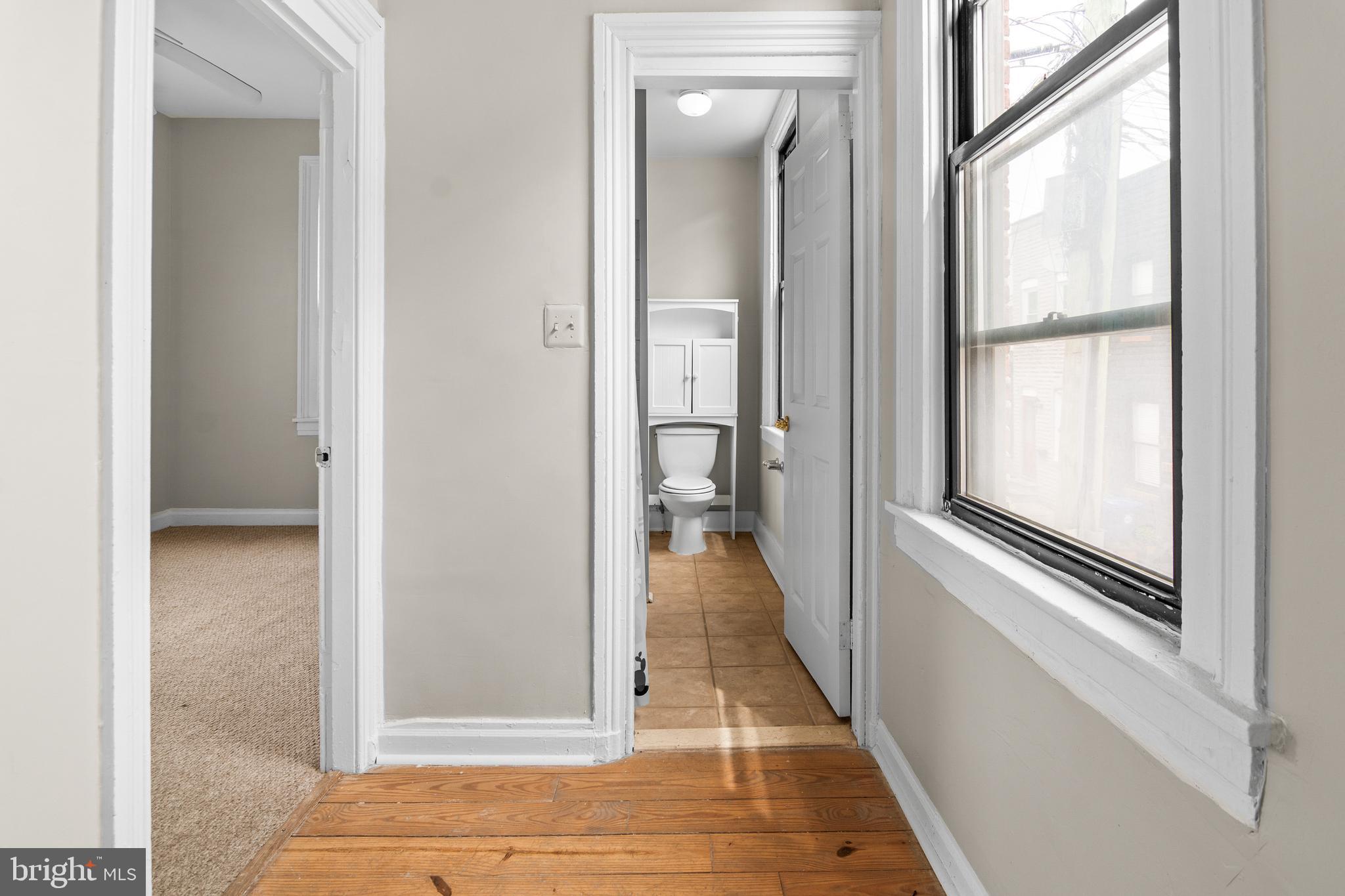 2112 Fleet Street Baltimore, MD 21231 - Photo 25 of 62 a view of a hallway with a glass door and a bathroom