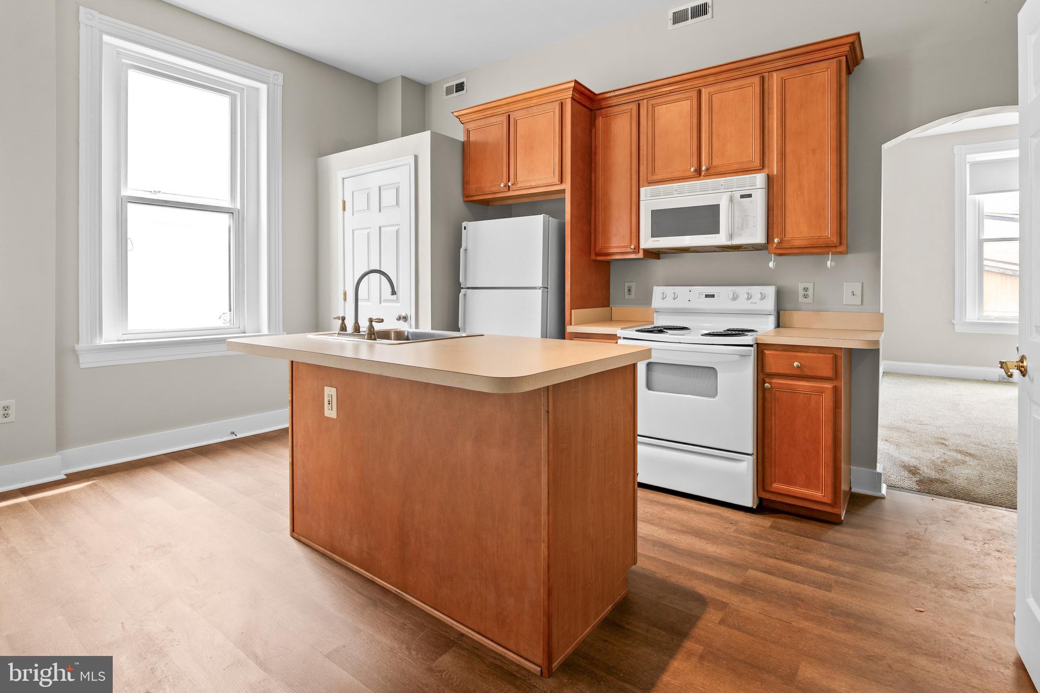 2112 Fleet Street Baltimore, MD 21231 - Photo 31 of 62 a kitchen with stainless steel appliances granite countertop a stove a sink dishwasher and a microwave oven with cabinets