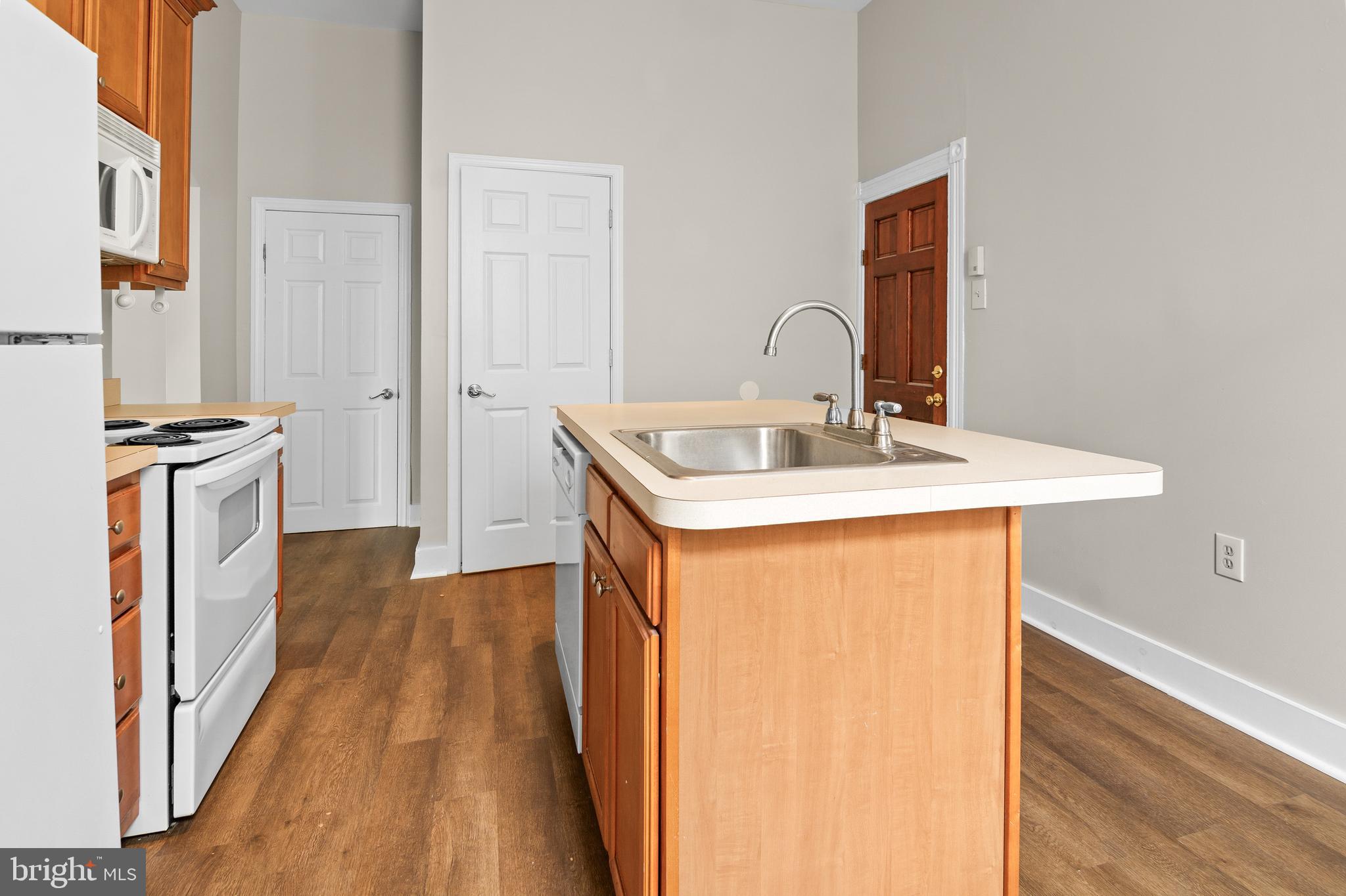 2112 Fleet Street Baltimore, MD 21231 - Photo 34 of 62 a kitchen with sink a refrigerator and wooden floor