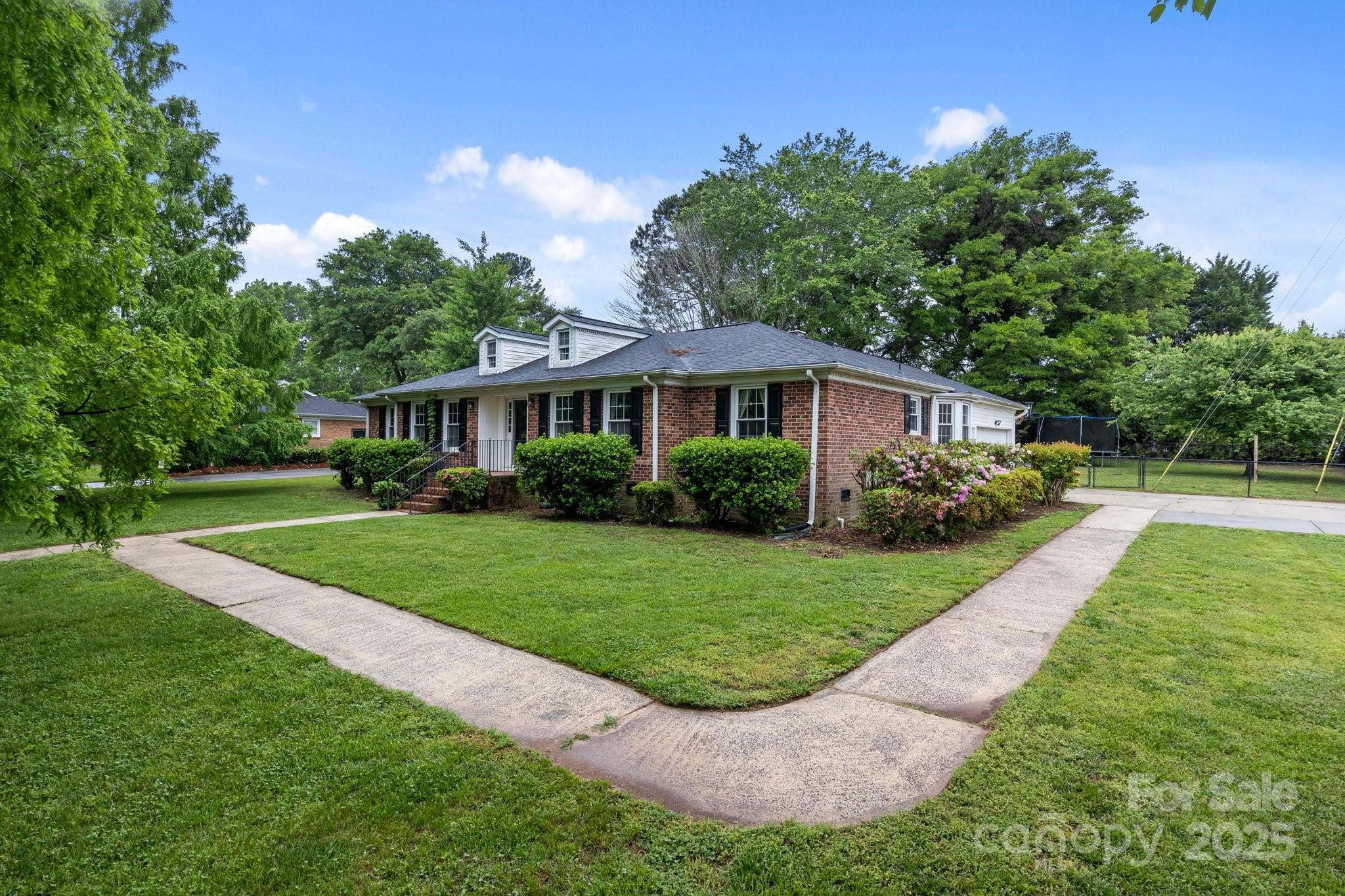 101 Wynnchester Road Gastonia, NC 28056 - Photo 33 of 46 a view of house in front of a big yard with potted plants and large trees