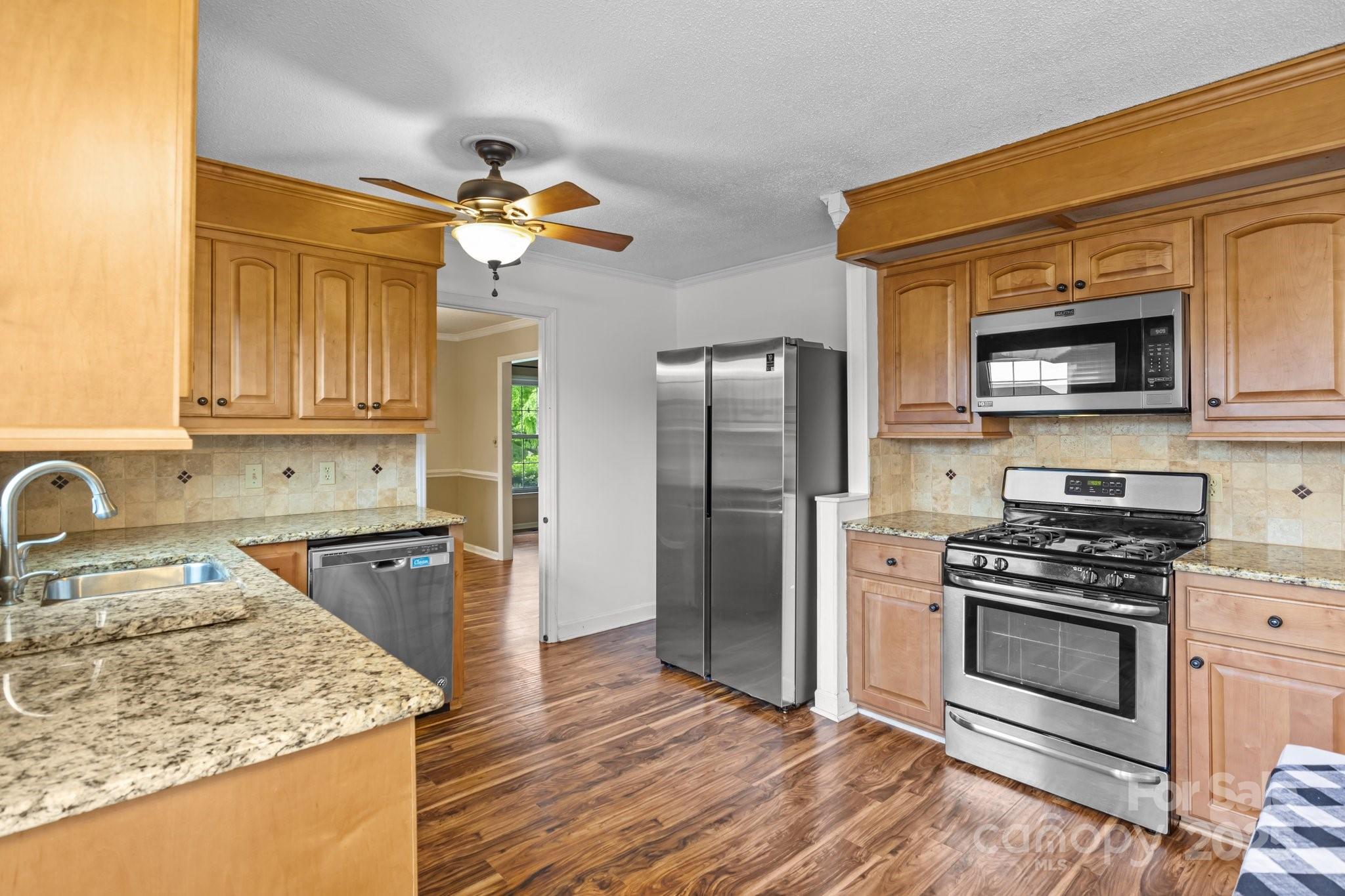 101 Wynnchester Road Gastonia, NC 28056 - Photo 8 of 46 a kitchen with stainless steel appliances granite countertop a sink stove microwave and refrigerator