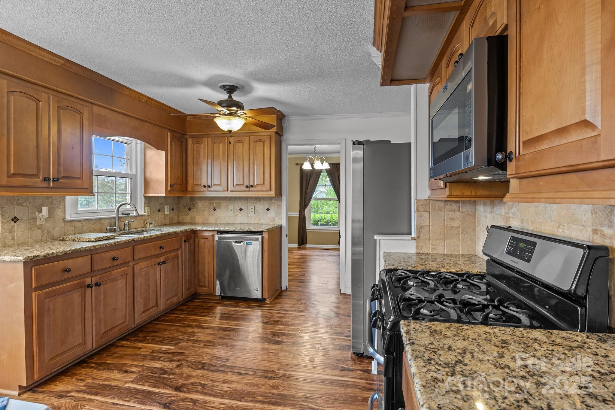101 Wynnchester Road Gastonia, NC 28056 - Photo 9 of 46 a kitchen with stainless steel appliances granite countertop a stove a sink and a microwave