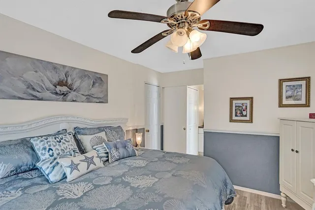 a bedroom with a large bed and a ceiling fan