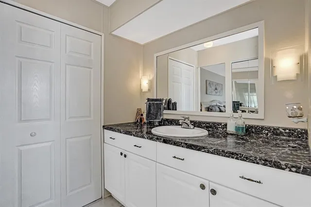 a bathroom with a granite countertop sink and a mirror