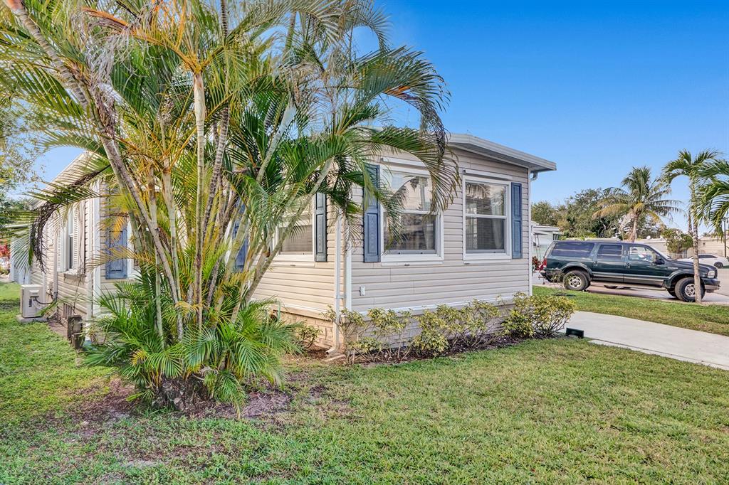 2301 Southwest 86th Terrace Davie, FL 33324 - Photo 30 of 31 a yellow house with a small yard and large trees
