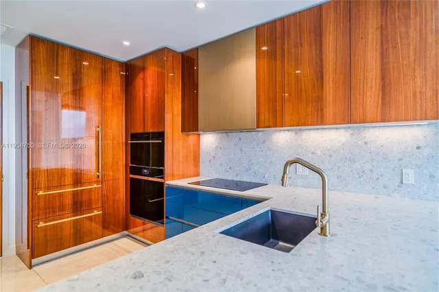 a kitchen with kitchen island granite countertop a stove and a microwave