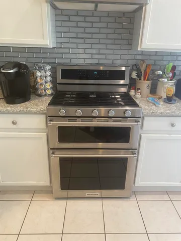 a stove top oven sitting inside of a kitchen