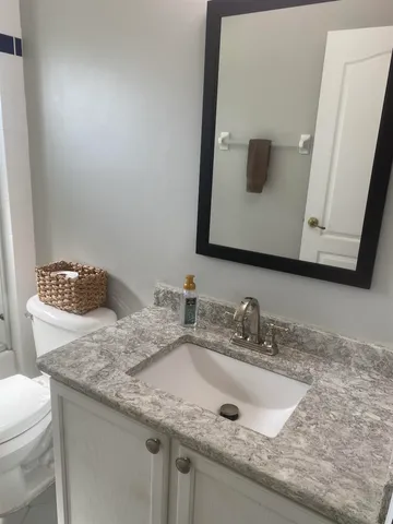 a bathroom with a granite countertop sink and a mirror