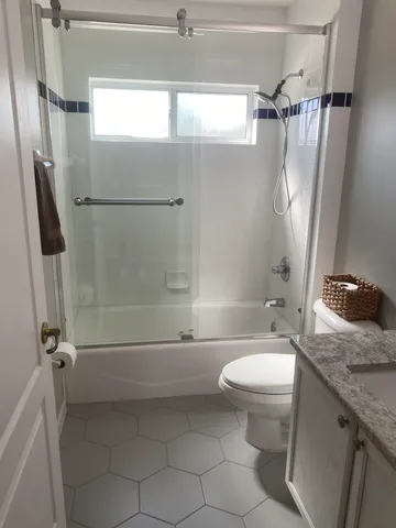 a bathroom with a granite countertop sink toilet and shower