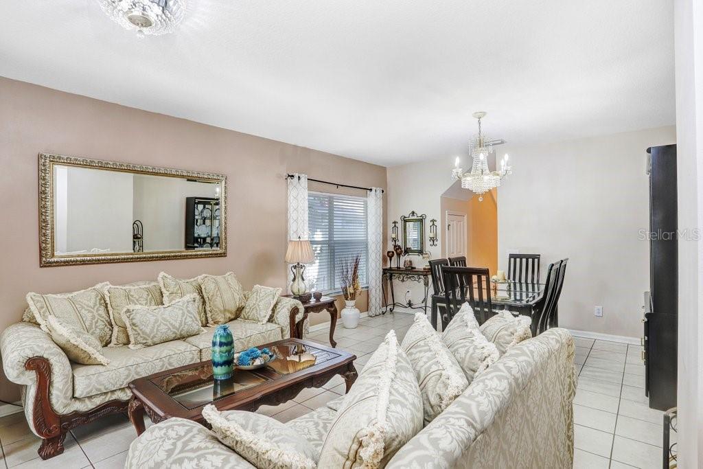 8638 Hawbuck Street Trinity, FL 34655 - Photo 14 of 43 a living room with furniture and a chandelier