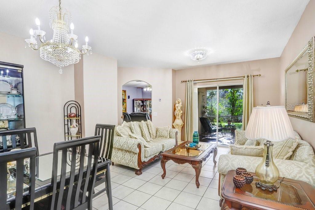 8638 Hawbuck Street Trinity, FL 34655 - Photo 15 of 43 a living room with furniture a chandelier and a large window