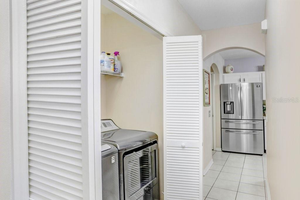 8638 Hawbuck Street Trinity, FL 34655 - Photo 21 of 43 a kitchen with a refrigerator and white cabinets