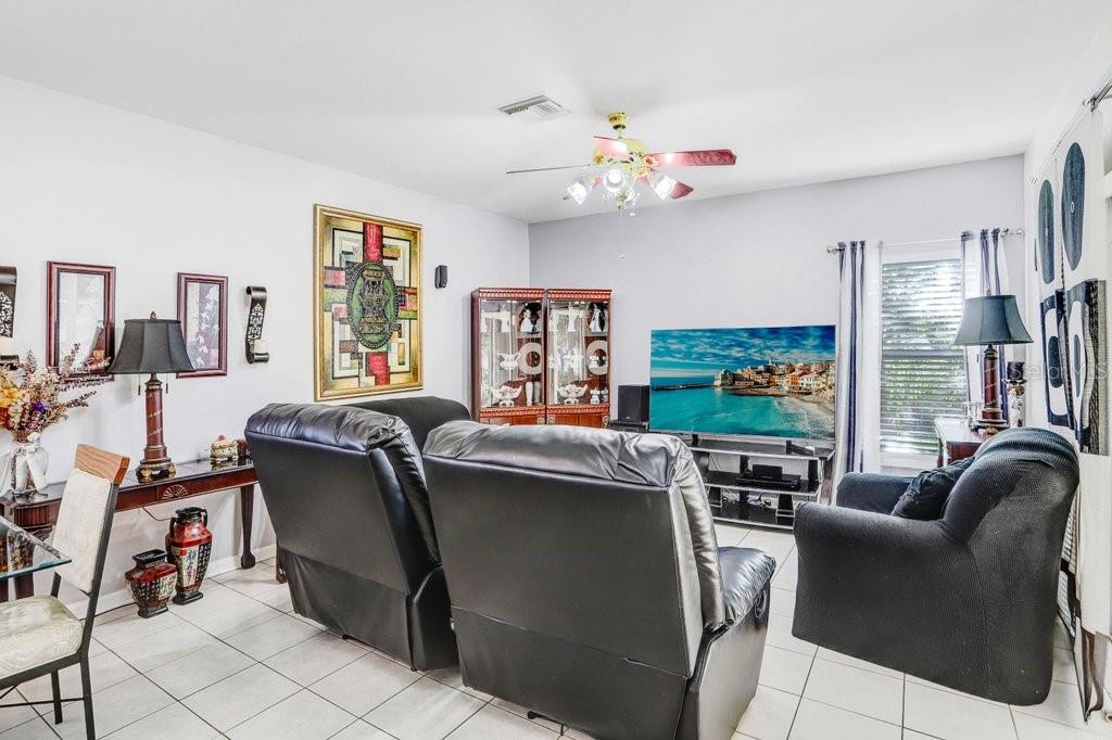 8638 Hawbuck Street Trinity, FL 34655 - Photo 22 of 43 a living room with furniture and a flat screen tv