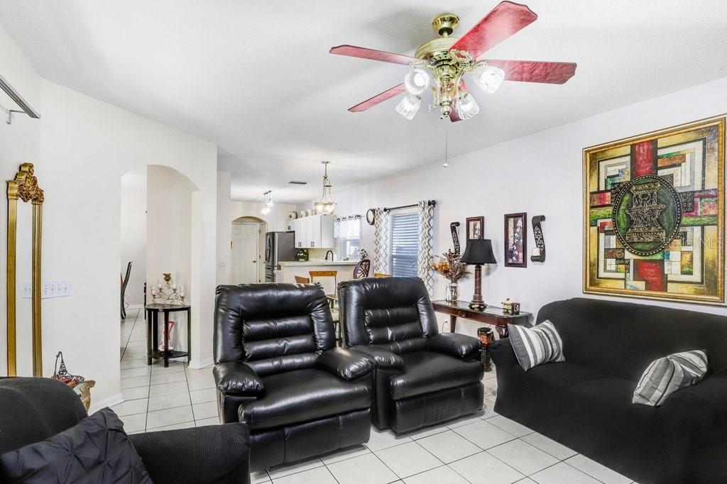 8638 Hawbuck Street Trinity, FL 34655 - Photo 23 of 43 a living room with furniture a chandelier and a flat screen tv