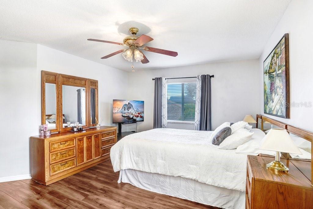 8638 Hawbuck Street Trinity, FL 34655 - Photo 25 of 43 a bedroom with a bed and wooden floor