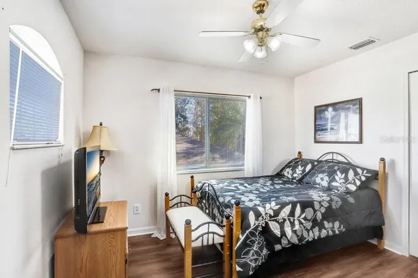 a bedroom with a bed and wooden floor