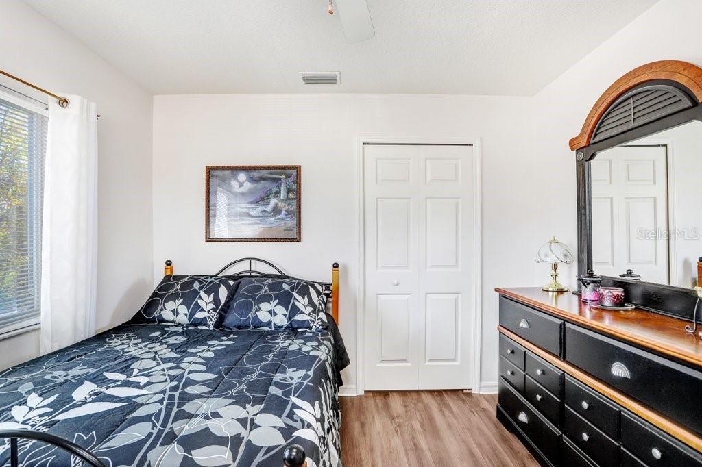 8638 Hawbuck Street Trinity, FL 34655 - Photo 28 of 43 a bedroom with a bed and wooden floor