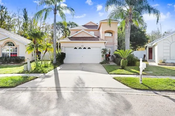 a front view of a house with a yard and potted plants