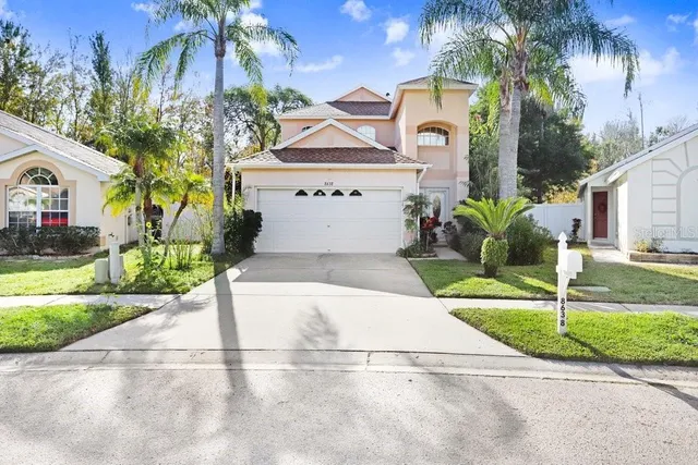 a front view of a house with a yard and potted plants