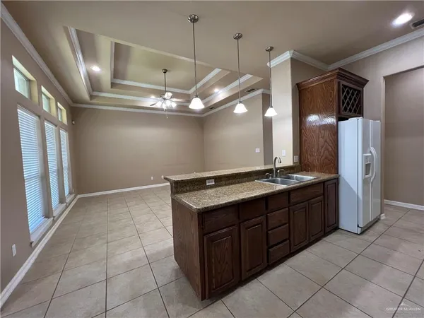 a spacious kitchen with a stove a refrigerator and a refrigerator