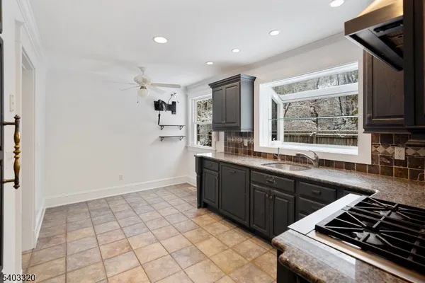 a kitchen with sink cabinets and a stove top oven