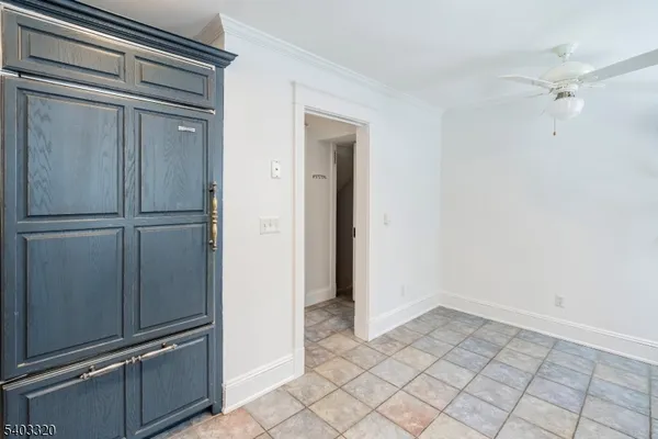 a view of a refrigerator in kitchen and white cabinets