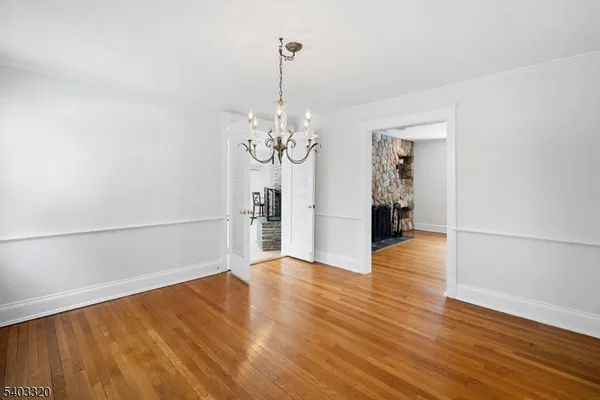 a view of a room with wooden floor and chandelier