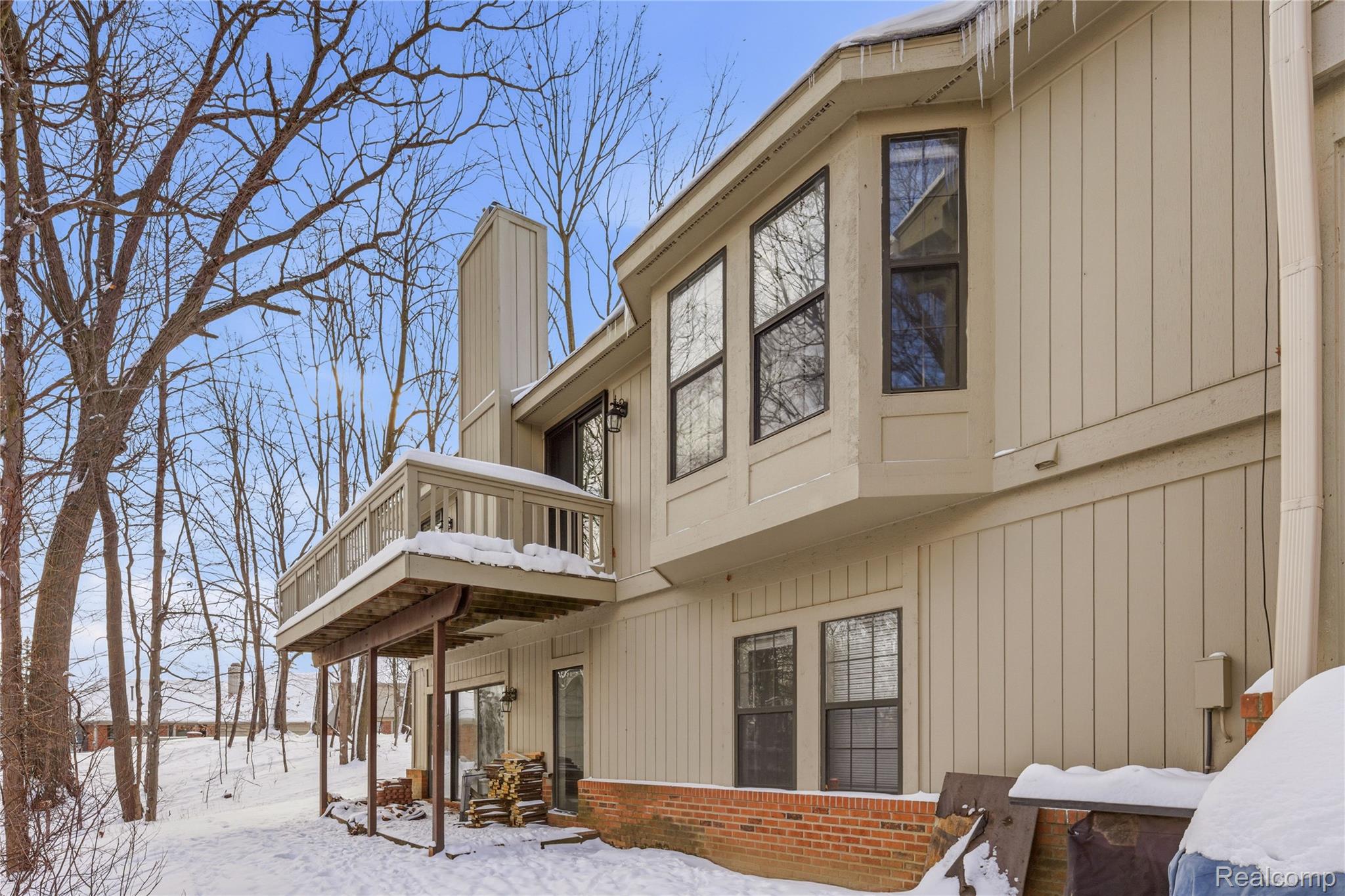 7154 Westchester Road West Bloomfield, MI 48322 - Photo 35 of 38 View of snow covered exterior featuring a chimney, a balcony, and brick siding