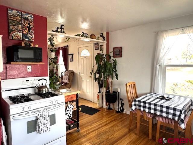 308 North Beech Street Cortez, CO 81321 - Photo 20 of 35 a view of kitchen and dining room with furniture window and wooden floor