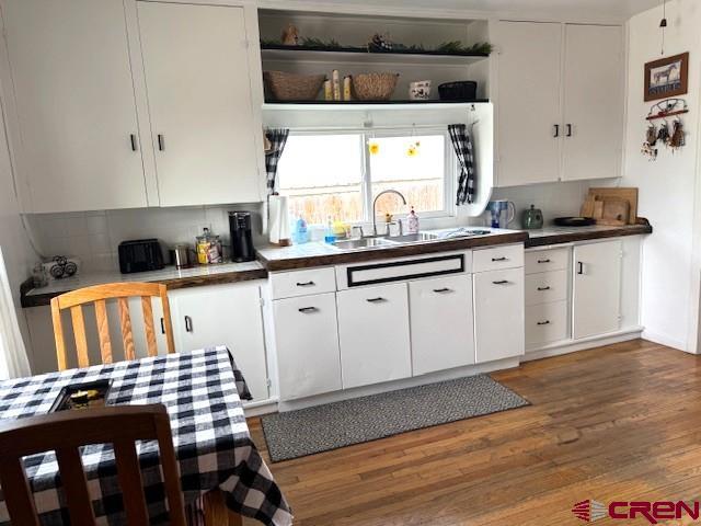 308 North Beech Street Cortez, CO 81321 - Photo 22 of 35 a kitchen with granite countertop a stove a sink and white cabinets