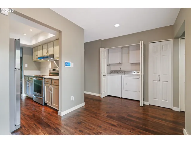 a view of kitchen with stainless steel appliances cabinets and wooden floor