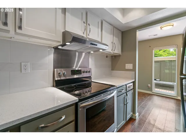 a kitchen with a stove and a wooden floor