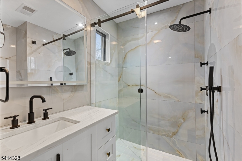 79 3rd Street Somerville, NJ 08876 - Photo 11 of 20 a bathroom with a shower sink vanity and mirror